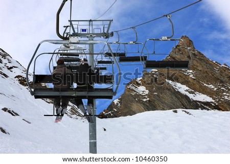 Sky is the limit. Skiers on chairlift at ski resort