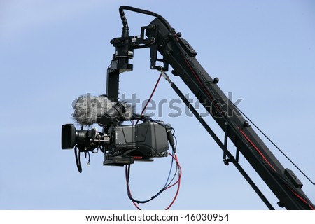 Camera on crane in action; blue sky as background