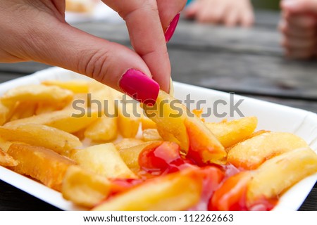 woman with pink nails eating chips