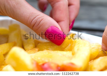 woman with pink nails eating chips