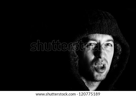 angry violent man with hood up screaming