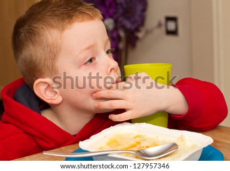 child eating an unhealthy processed dinner in front of the TV