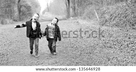 brothers holding hands together on a country path