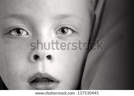 little boy alone with his mouth open black and white