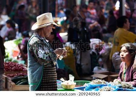 CHICHICASTENANGO, GUATEMALA - MAY 9: A man is buying vegetables at a weekly market in Chichicastenango (Chichi), Guatemala on 9 May 2013.