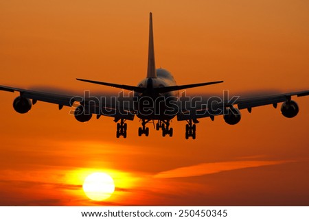 Passenger airplane landing while the sun is rising.