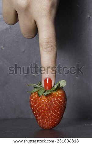 strawberry and finger with red nail