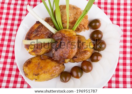 baked potato and minced chicken patty on a tablecloth