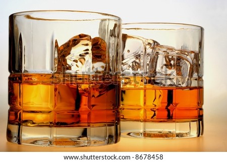 Close-up of liquor and ice in glasses on a white background.