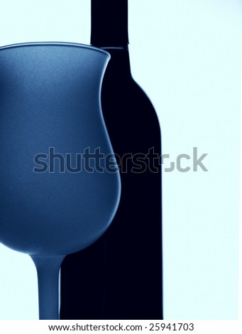 Black and white grainy photo of wine bottle and colored glass.