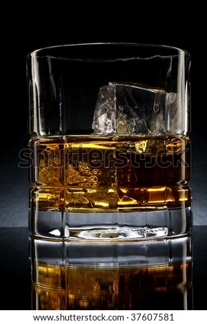 Close-up of liquor and ice in glasses on a black background.