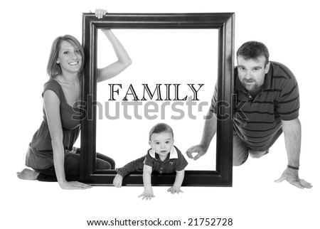 Portrait of a family looking through a large wooden frame. In black and white.