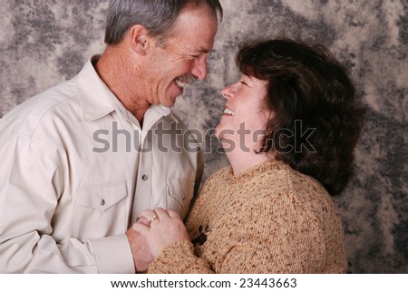 Happy middle aged couple smiling at each other.
