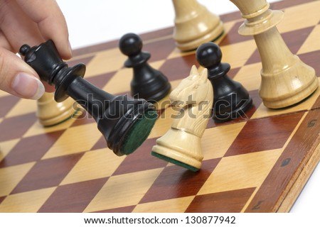 Picture shows a chess game. The horse is hitting by queen. Studio light.