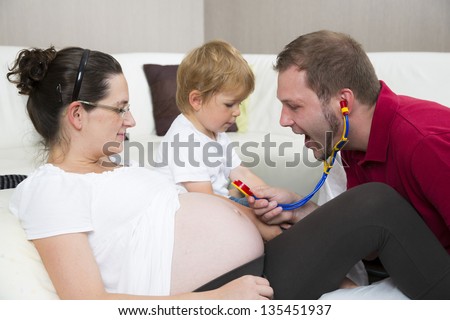 Mom with her son and husband playing doctor.