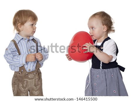 Photo shows two kids. She gives him a heart. The heart is a ballon. Studio light with white background
