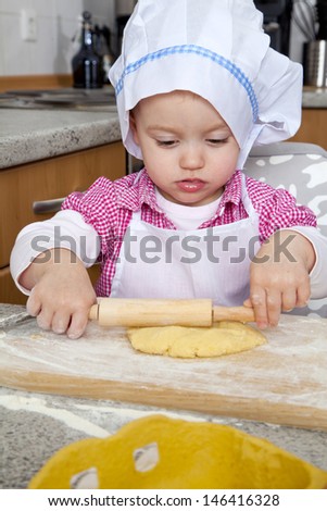 Little girl is baking cakes for christmas.