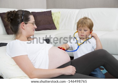 Mom and her son playing doctor. Mom is pregnant.