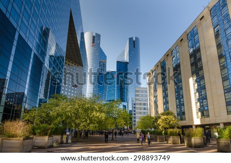 PARIS, FRANCE - OCTOBER 27, 2014: People walk along Cours Valmy, a pedestrian walkway behind La Grande Arche in La Defense, the commercial and business center in the Parisian capital.