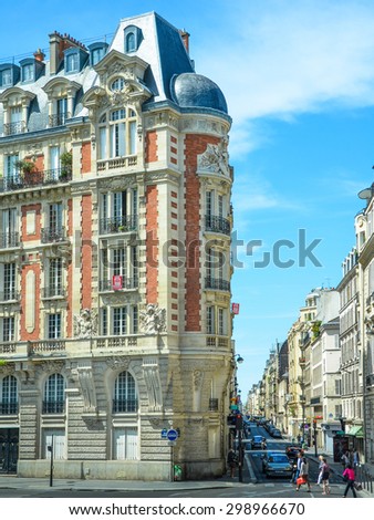 PARIS, FRANCE - MAY 29, 2011: People are crossing Rue de Vaurigard at Rue Guynemer. The intersection is dominated by a beautifully restored neoclassical  apartment building from the 18th century.