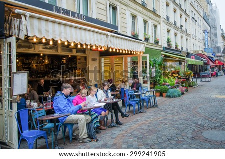 PARIS, FRANCE - OCTOBER 7, 2014: A family checks out the lunch menu at an outdoor cafe in the charming Rue Cler neighborhood.