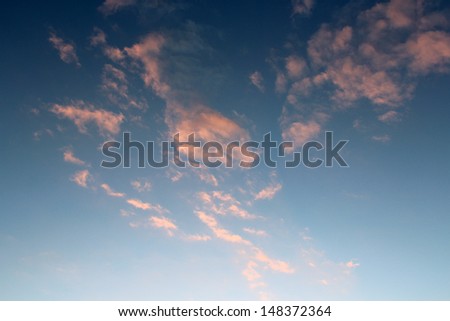 Dainty wispy pale salmon pink clouds  at sunset  in a  blue Australian sky in  late winter  add color to the skyscape as evening approaches.