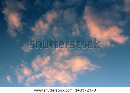 Dainty wispy pale salmon pink clouds  at sunset  in a  blue Australian sky in  late winter  add color to the skyscape as evening approaches.