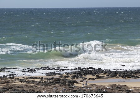 Indian Ocean waves breaking on basalt rocks at  Ocean beach Bunbury Western Australia on a fine sunny  afternoon in mid summer are cool and refreshing.