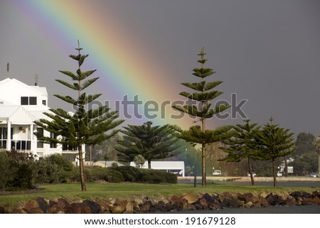Colorful rainbow over the Leschenault Estuary Bunbury Western Australia  near the Flood gates on a stormy afternoon in late autumn.