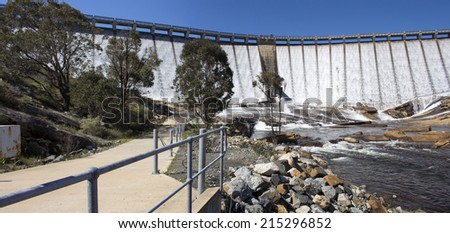 Water streaming and overflowing  over the  massive concrete wall and slipway  of Wellington Dam near Collie Western Australia on a  fine morning in spring after heavy rainfall upstream.