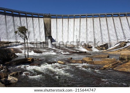 Water streaming and overflowing  over the  massive concrete wall and slipway  of Wellington Dam near Collie Western Australia on a  fine morning in spring after heavy rainfall upstream.
