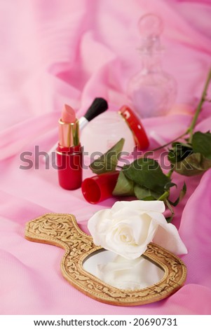 a photo of white rose and cosmetics on the bed