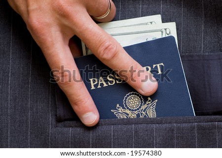 Hand on American passport with bills in business coat pocket. See more passport images in my portfolio.