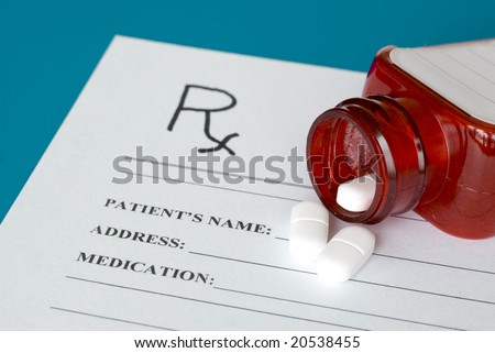 Prescription pills and red bottle on Rx form