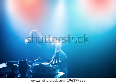 Dj man with headphones playing on vinyl in a nightclub