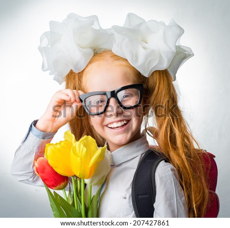Girl with a bouquet of flowers, a backpack, glasses smiling. Soon the school.