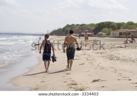 Young men walking on the beach