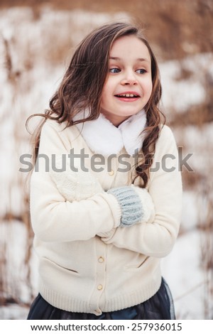 cute child girl is cold on the walk in winter