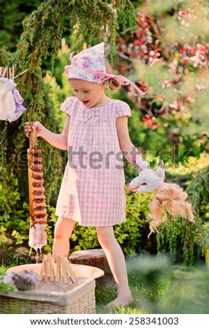 child girl playing toy wash in summer garden