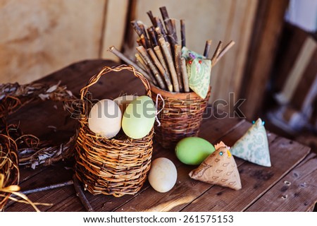 easter eggs and fabric chicken on wooden table in country house in spring