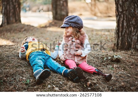 two toddler friends having fun and playing on the walk in spring forest