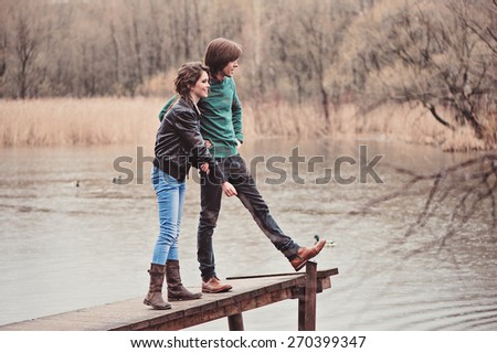 young loving couple on the walk on spring river side