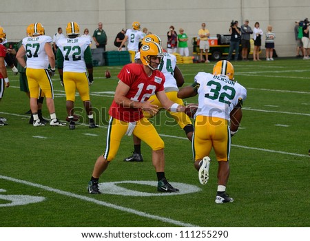 GREEN BAY, WI - AUGUST 19 : Green Bay Packers Quarterback Aaron Rodgers Hands Off the Football to Cedric Benson During Training Camp Practice on August 19, 2012 in Green Bay, WI