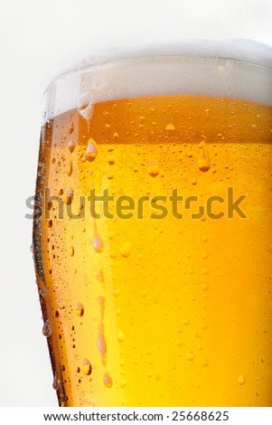 Fresh glass of beer with froth and condensed water pearls on white background