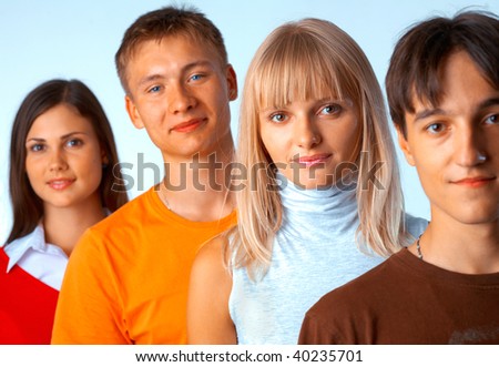 Young people standing in a row on light blue background