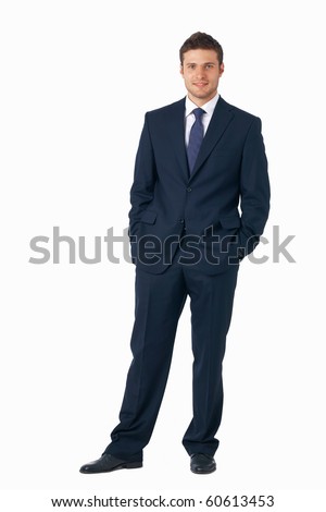 Full length portrait of a young businessman standing with his hands in the pockets.