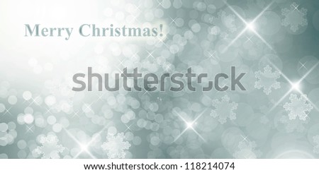 Silver winter background with defocused lights,  snow flakes and text Merry Christmas