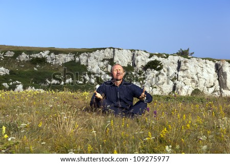 The meditating man in sportswear in mountains