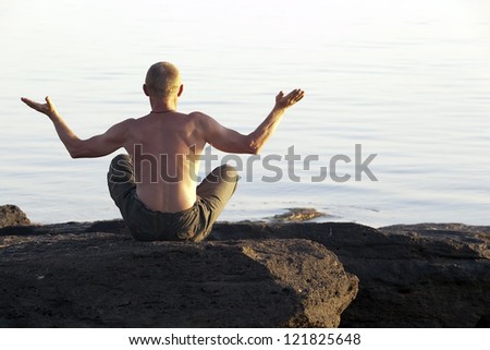 The meditating man ashore the seas, sitting a back