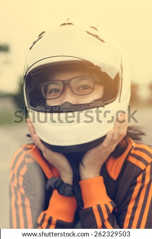 Asian girl happiness is her vacation by riding her motorcycle and good safety gear such as the helmet to somewhere in the world.